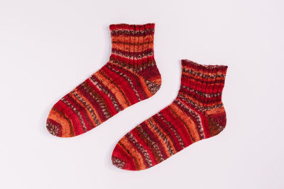 Pair of red and orange striped knitted socks from sectional yarn. warm winter wool socks. 