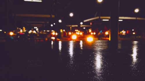 Illuminated city street during rainy season at night