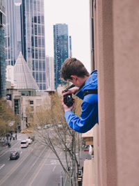 Man photographing building in city