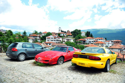 Cars on road against sky in city