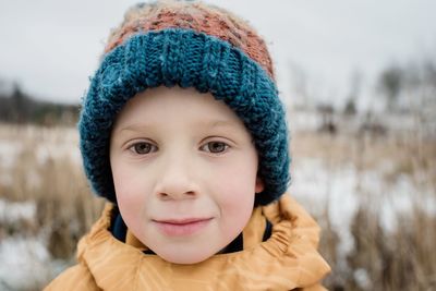 Portrait of a young boy looking whilst playing outside in winter