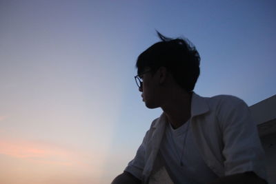 Low angle view of man against sky during sunset