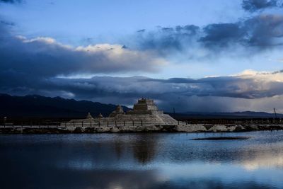 View of lake against cloudy sky at night
