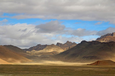 Scenic view of mountains against cloudy sky