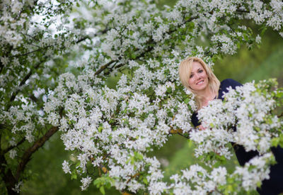 Portrait of a smiling young woman with flower tree