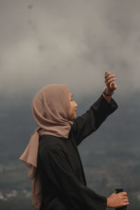 Side view of man standing against the sky