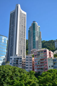 Low angle view of modern buildings against clear blue sky