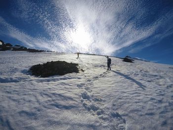 Man on snowcapped mountain against sky during winter