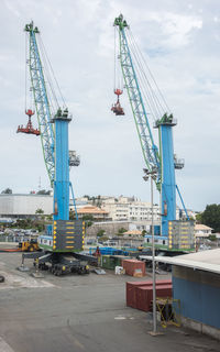 Cranes at construction site against sky