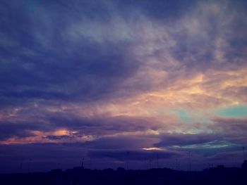 Silhouette of trees against cloudy sky