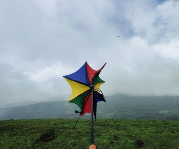 Multi colored umbrella on land against sky