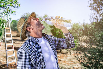 Portrait of young man drinking glass