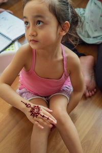 Blurry photo of henna ornaments on little girl's hand closeup.