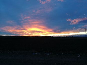 Scenic view of field against sky at sunset