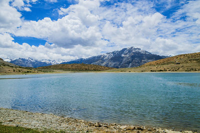 Scenic view of lake by mountains against sky