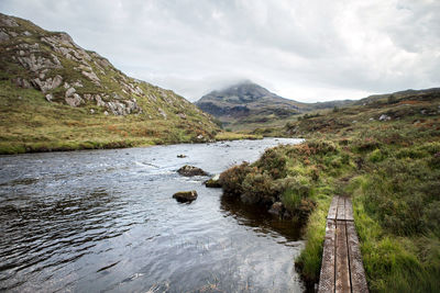 Calm lake surrounded by mountain range