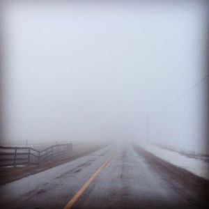 Road passing through foggy weather