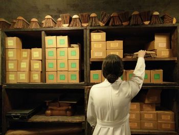 Rear view of man standing in shelf