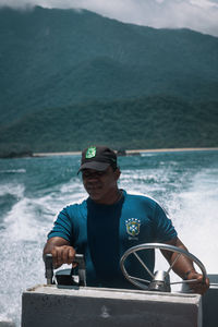 Man standing on boat against sea