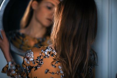 Rear view of woman reflecting in mirror