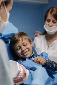 Dentists examining boy in clinic