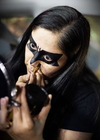 Close-up of mature woman painting face