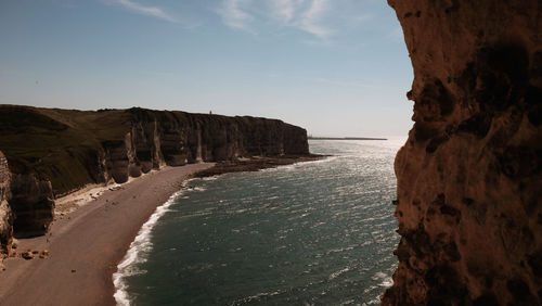 Rock formations on beach against sky