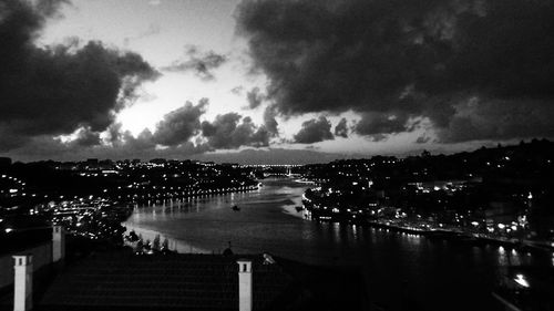 View of illuminated city against cloudy sky