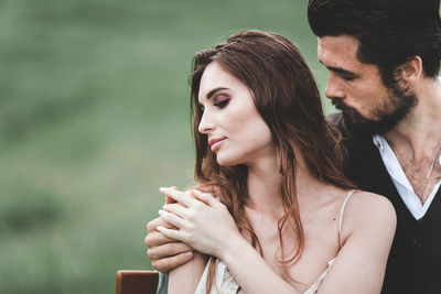 Close-up of wedding couple romancing on field