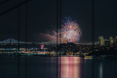 Firework display over river at night