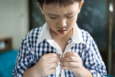 Close-up of boy wearing shirt