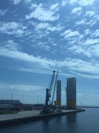 Modern buildings by sea against sky