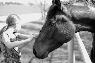 Girl standing by horse