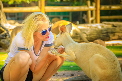 Full length of woman crouching by kangaroo