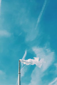 Low angle view of smoke emitting from chimney against sky