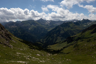 Scenic view of valley and mountains against sky