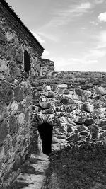 Stone wall of building against sky