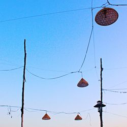 Low angle view of cables against clear blue sky