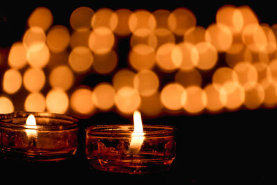 Close-up of illuminated tea light candles on table