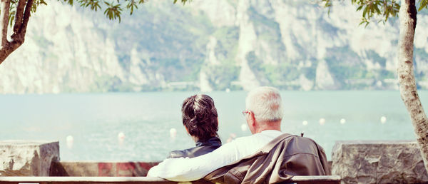 Rear view of couple relaxing on bench