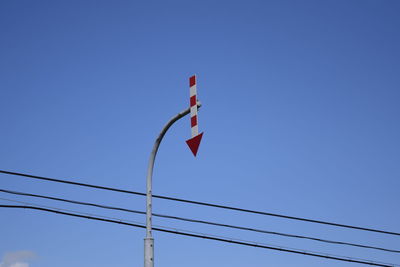 Low angle view of flags against clear blue sky