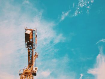 Low angle view of crane at construction site against sky