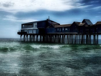 Built structures by sea against sky