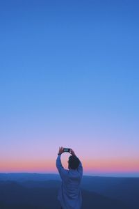 Cinematic view of man photographing against clear aesthetic sky during sunset