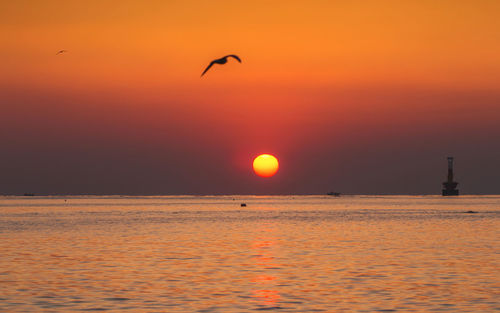 Scenic view of sea against orange sky