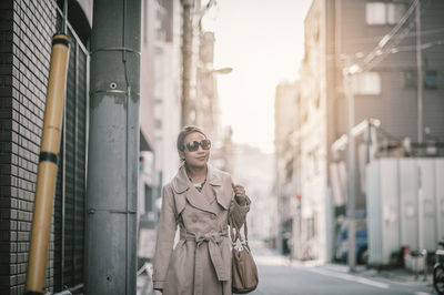 Young woman wearing sunglasses on street in city