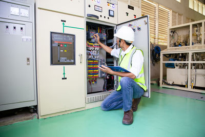 Maintenance engineers inspect relay protection system. bay control unit. medium voltage switchgear