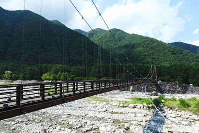 Bridge over mountain against sky