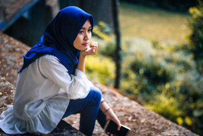 Side view of young woman looking away outdoors