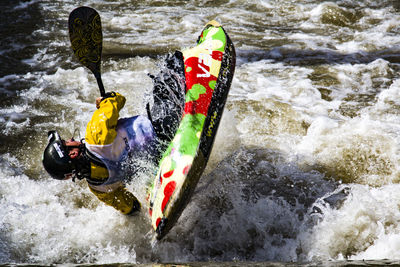 Rear view of man kayaking in river